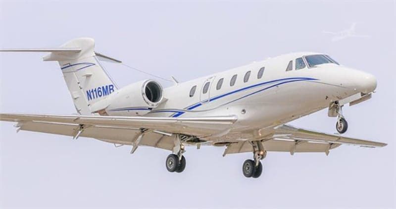 Cessna Citation aircraft N116MB in flight with landing gear down.