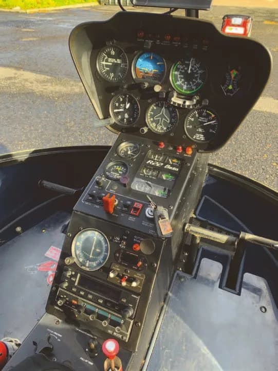 The instrument panel and central console of a Robinson R22 Beta helicopter cockpit.
