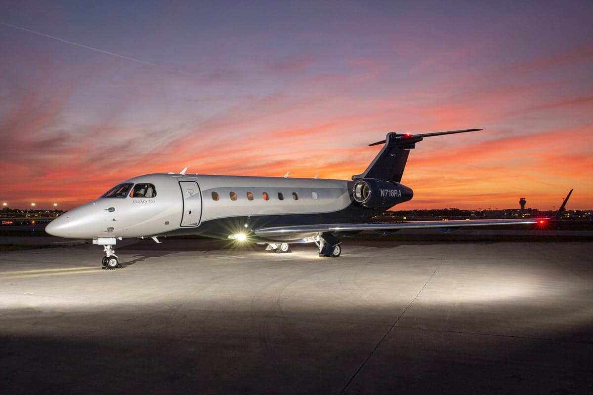 Embraer Legacy 500 aircraft on the ground at sunset.