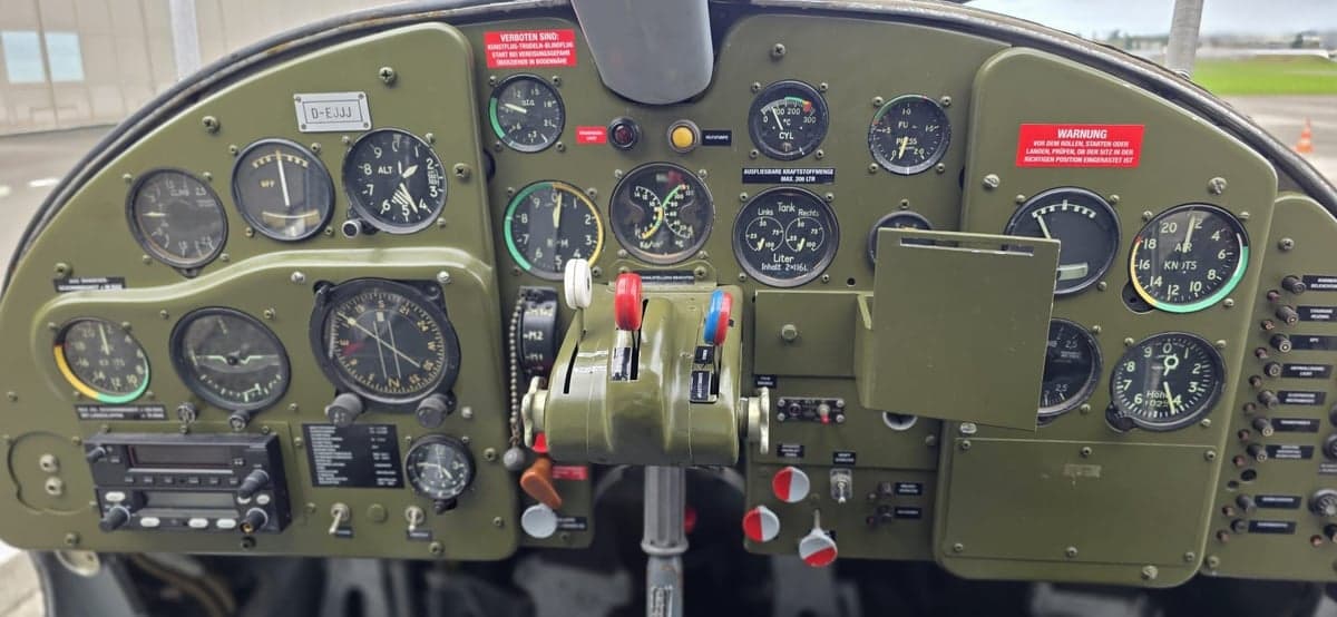 Close-up of the instrument panel of a gray and green aircraft.