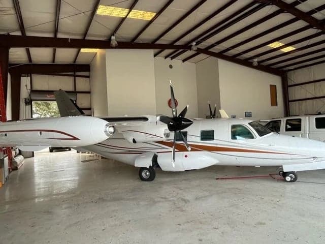 A white and brown paint scheme adorns this aircraft parked inside a hangar.