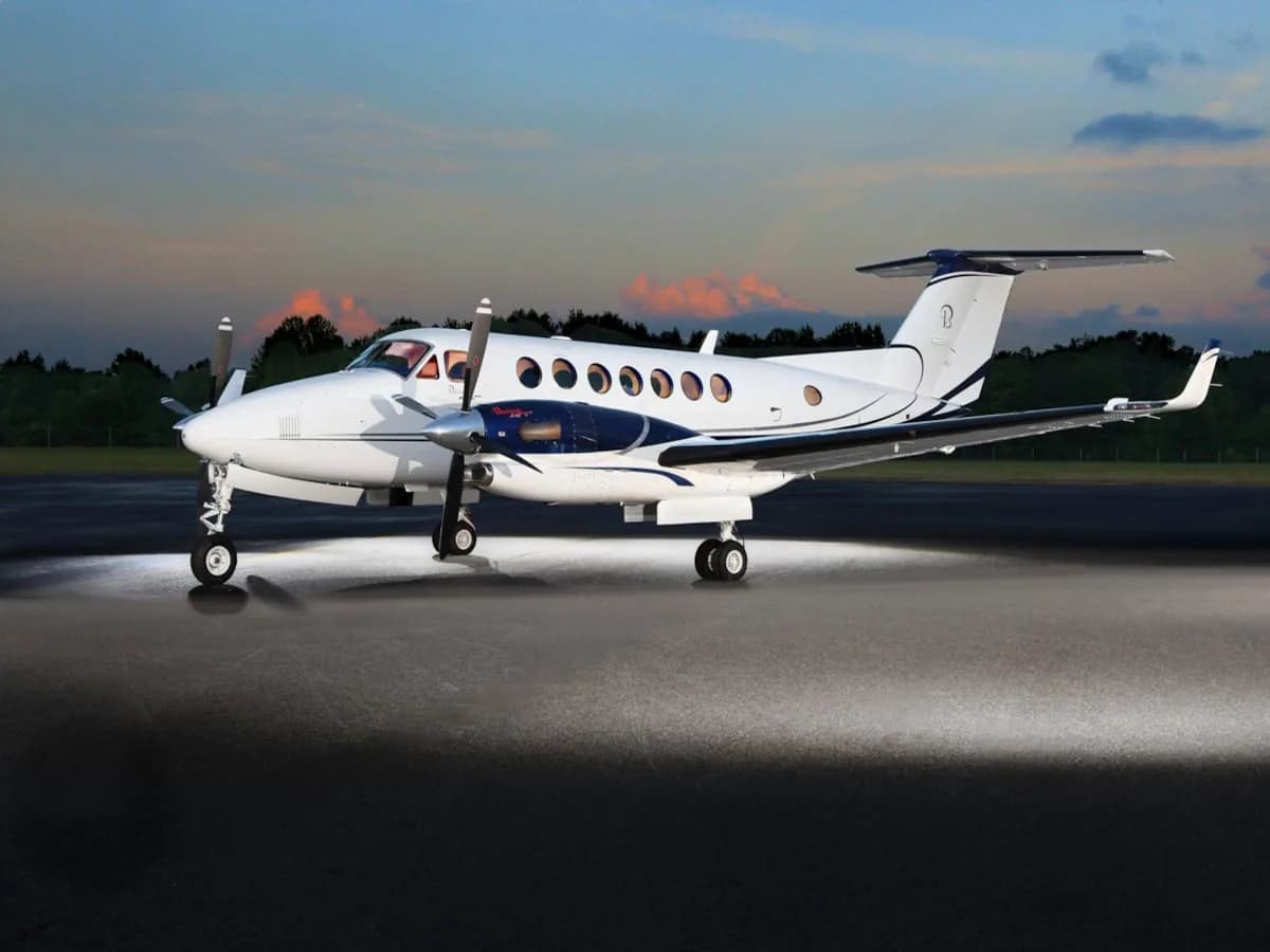 King Air on the tarmac at dusk with landing lights on.