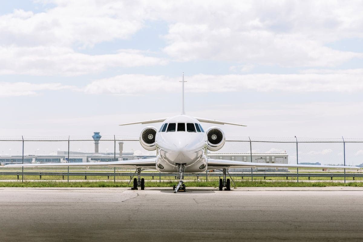 Front view of the aircraft on the tarmac, with a control tower in the background.