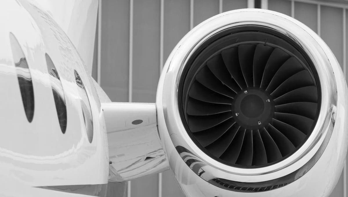 Close up of a jet engine and fuselage in black and white.