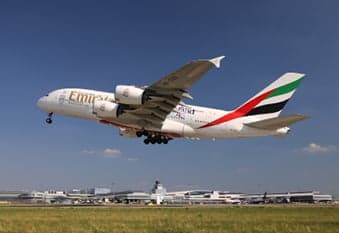 Etihad Airbus A380 in flight over clouds.