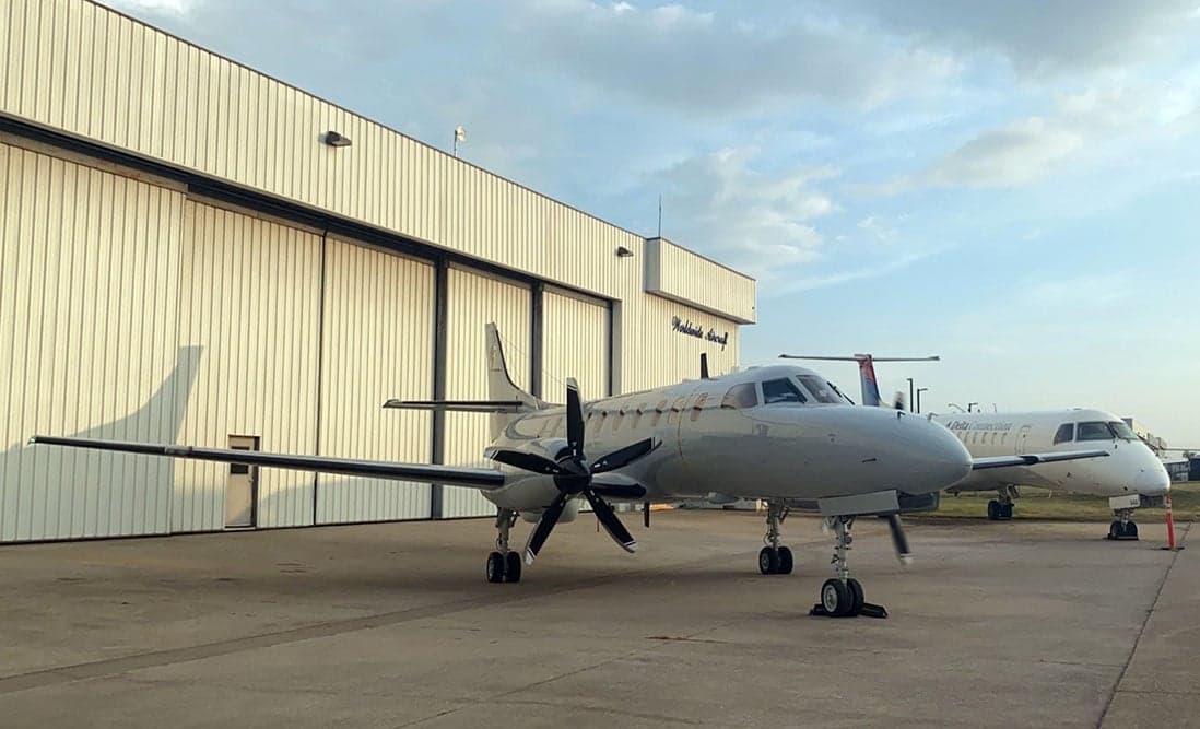 A Metro aircraft parked in front of a hangar.