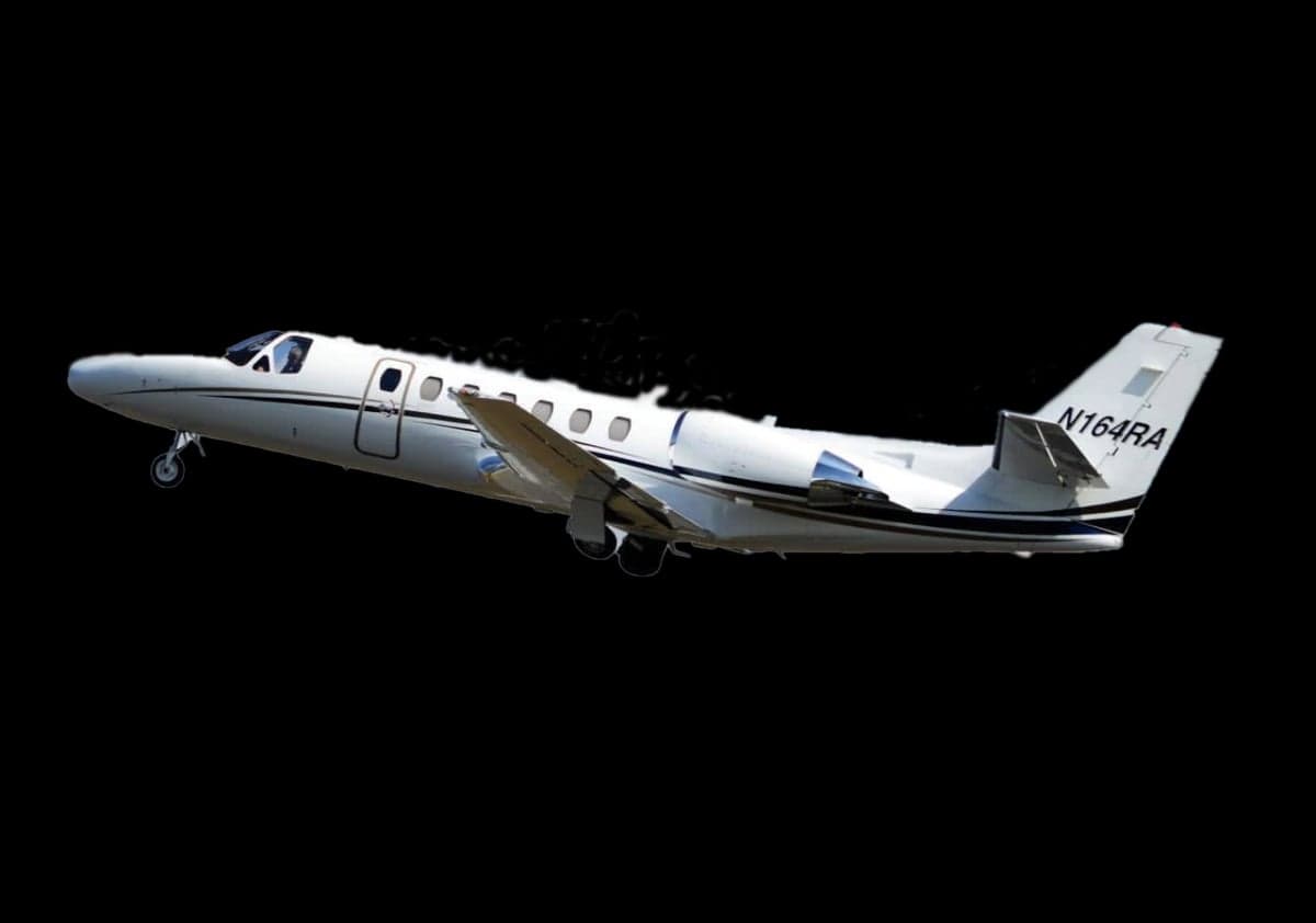 A white Cessna Citation CJ3 with registration N164RA is shown in flight against a black background.
