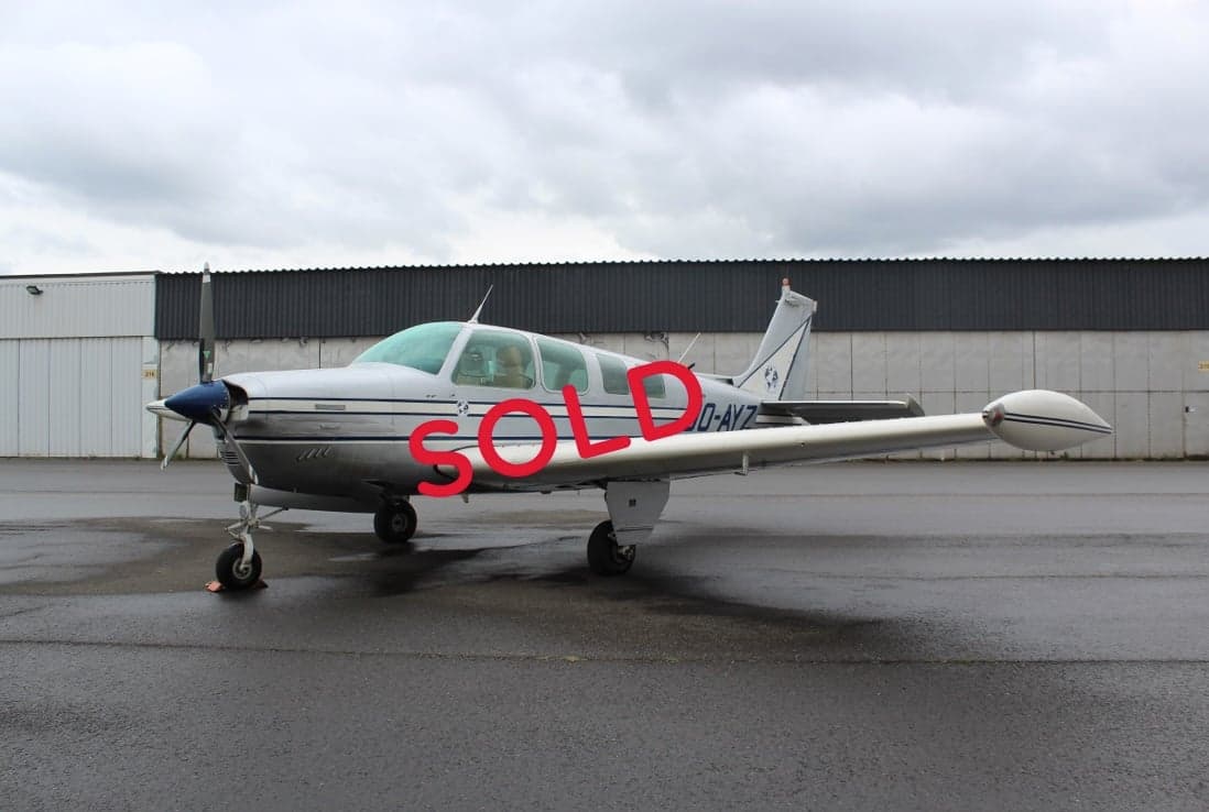 A Beechcraft Bonanza with registration OO-AYZ is parked on the tarmac.