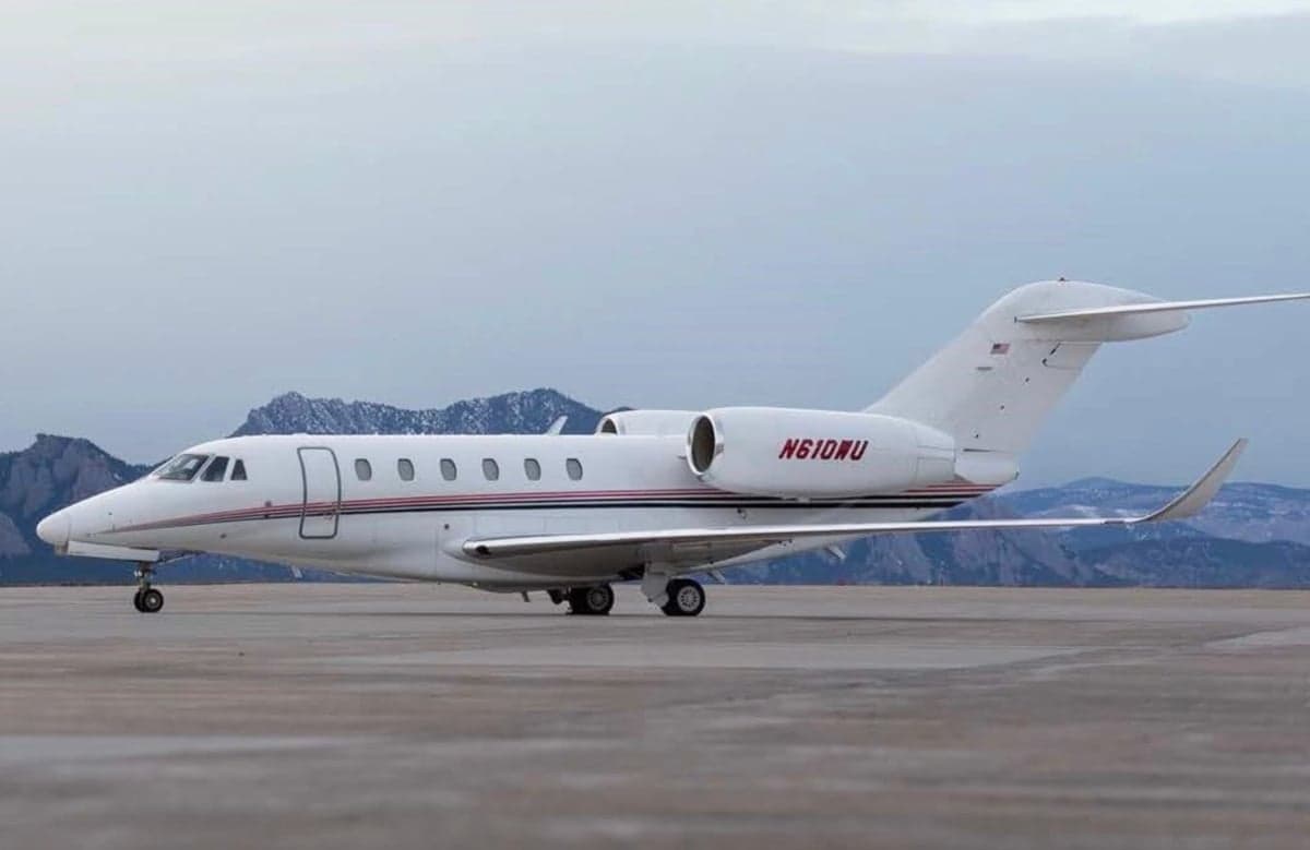 A white Cessna Citation CJ4 with red stripes and tail number N610WU parked on the tarmac.