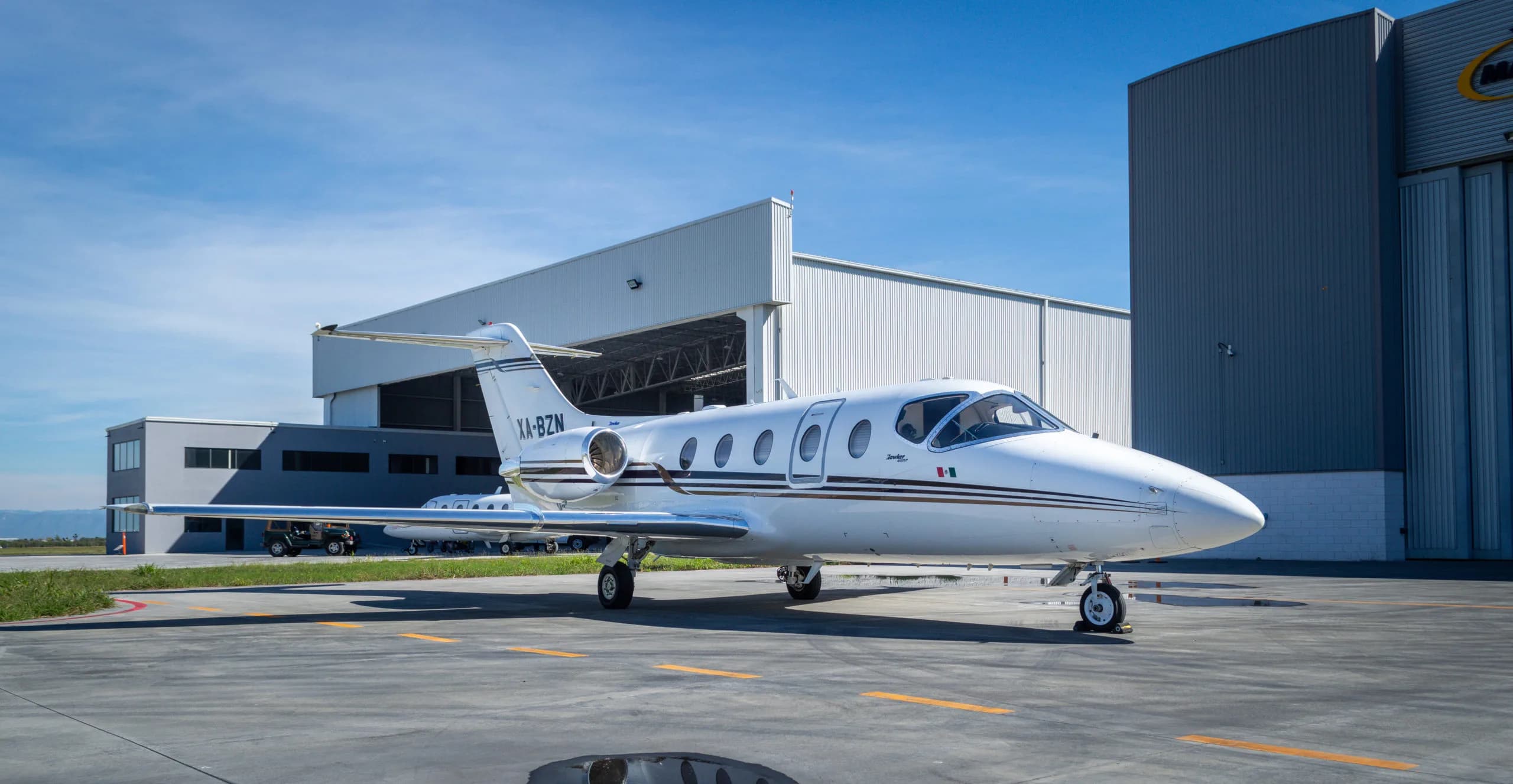 XA-BZN Learjet parked on the tarmac in front of a hangar.