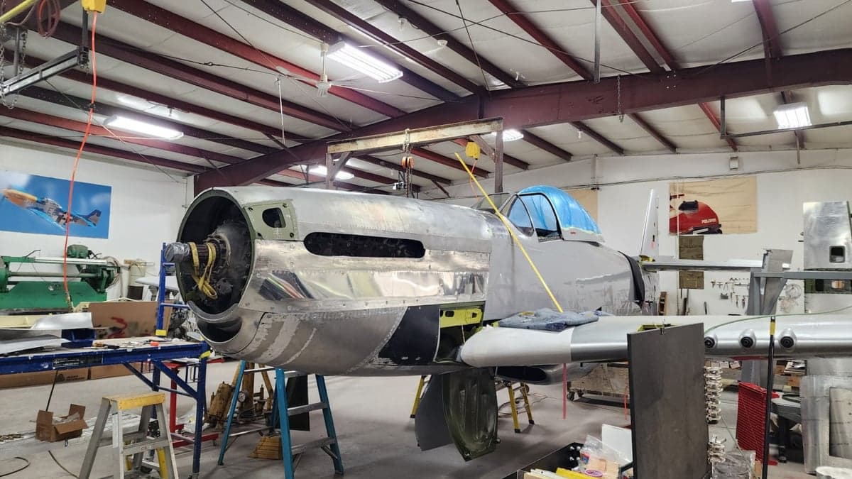 A partially assembled aircraft in a hangar setting.