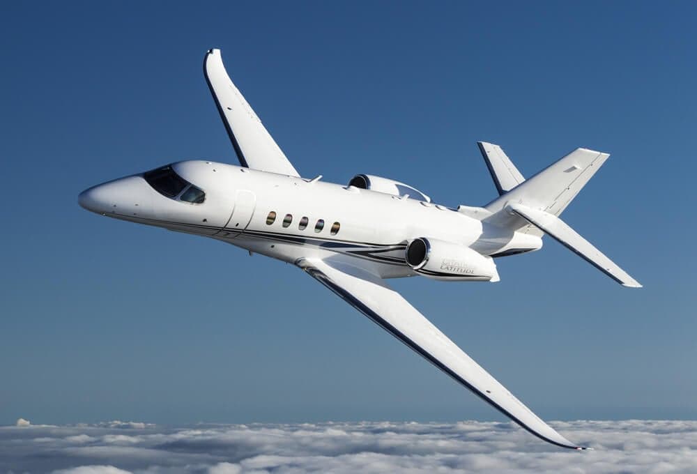 A Cessna Citation Latitude flying above the clouds.