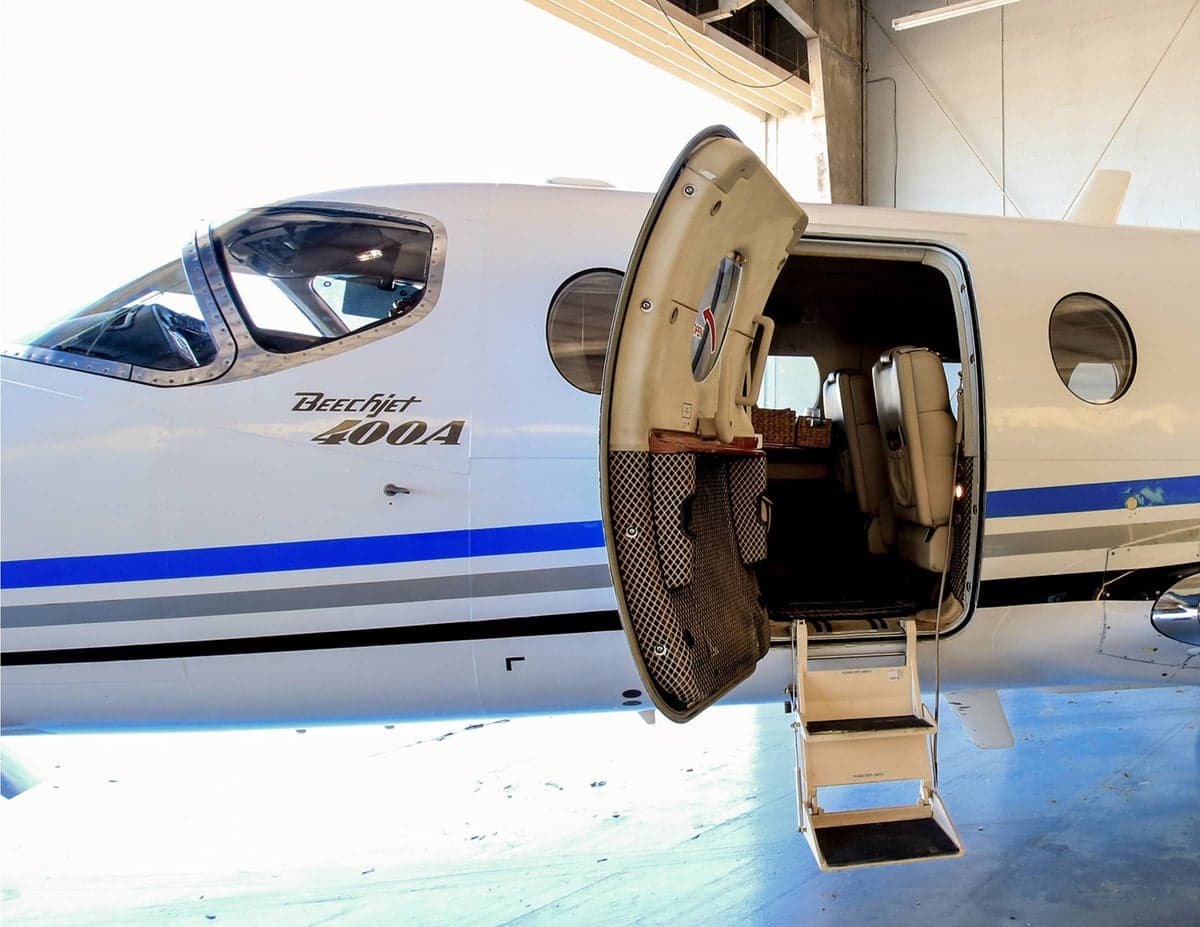 Close up of a Beechjet 400A with the door open and stairs extended.