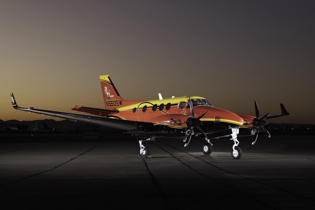 Close-up of a red and yellow King Air C90B aircraft.