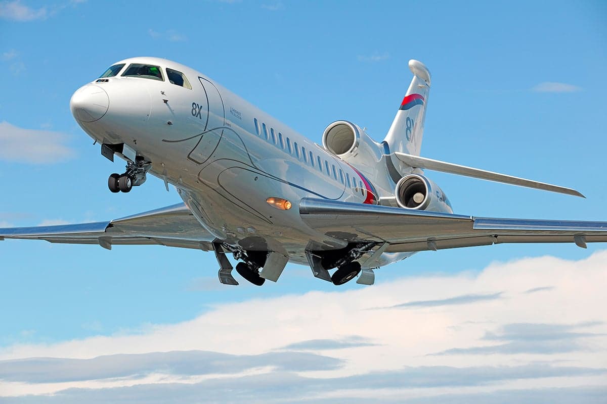 A Falcon 8X taking off with landing gear down.