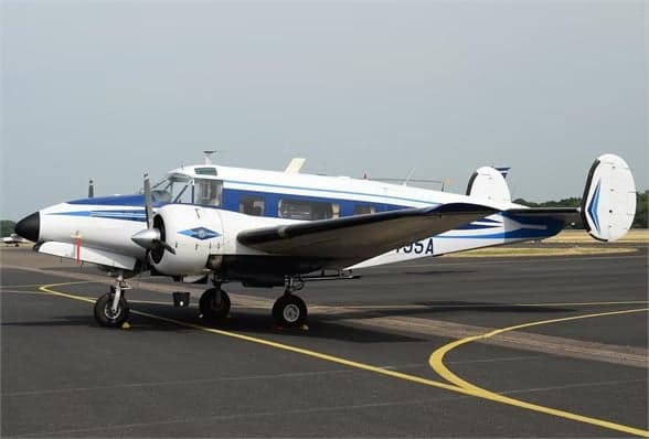 Beechcraft Model 18 with registration N8495A on the runway.