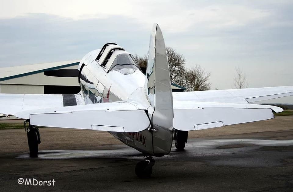 Rear view of a polished aircraft with black stripes.