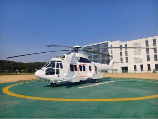 A white Airbus Helicopters H175 is parked on a helipad.
