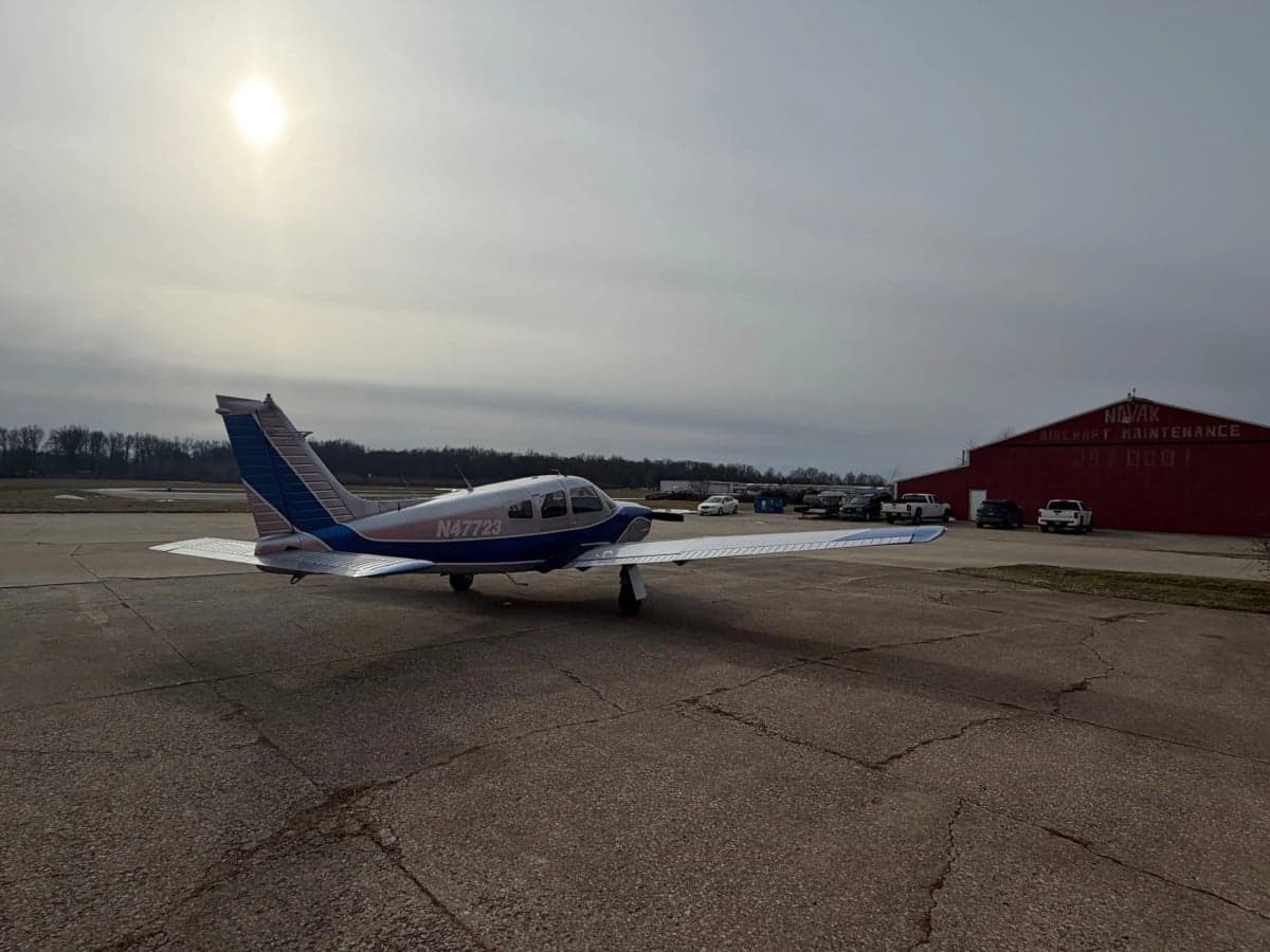 A Piper PA-28-181 Archer II aircraft with registration N47723 parked on the tarmac in front of a hangar.