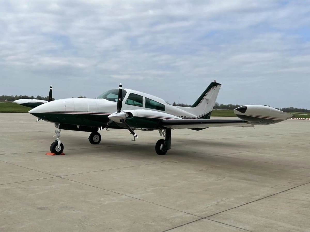 N4264J is a white and green Beechcraft Bonanza on the tarmac.