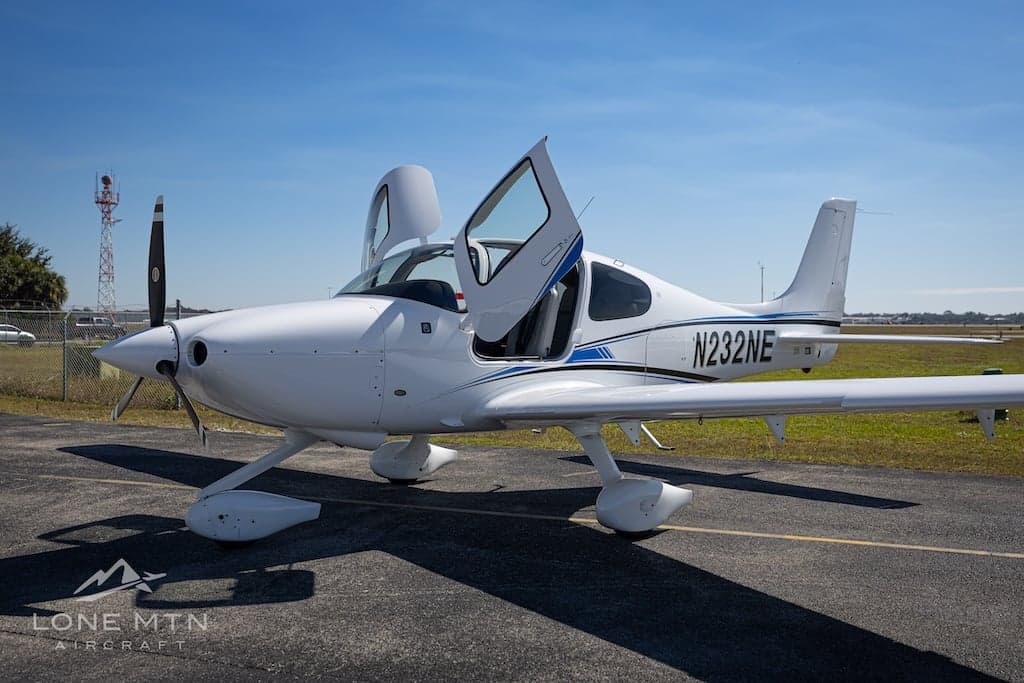 Cirrus SR22T aircraft N232NE with open doors on the tarmac.