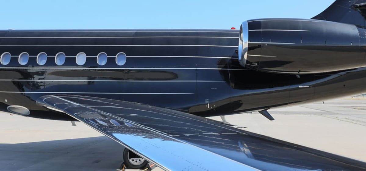 Close-up of the aircraft's wing and engine, showing the black paint scheme.