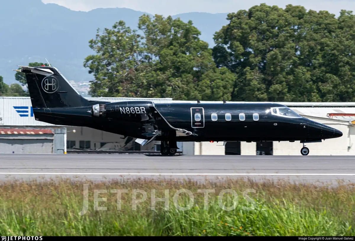 A black Learjet 35A with registration N86BR is shown on the runway.