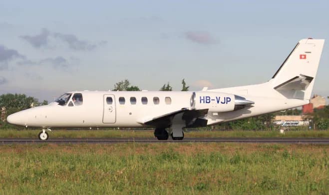 Side view of a white jet with Swiss flag on the tail, registration HB-VJP.