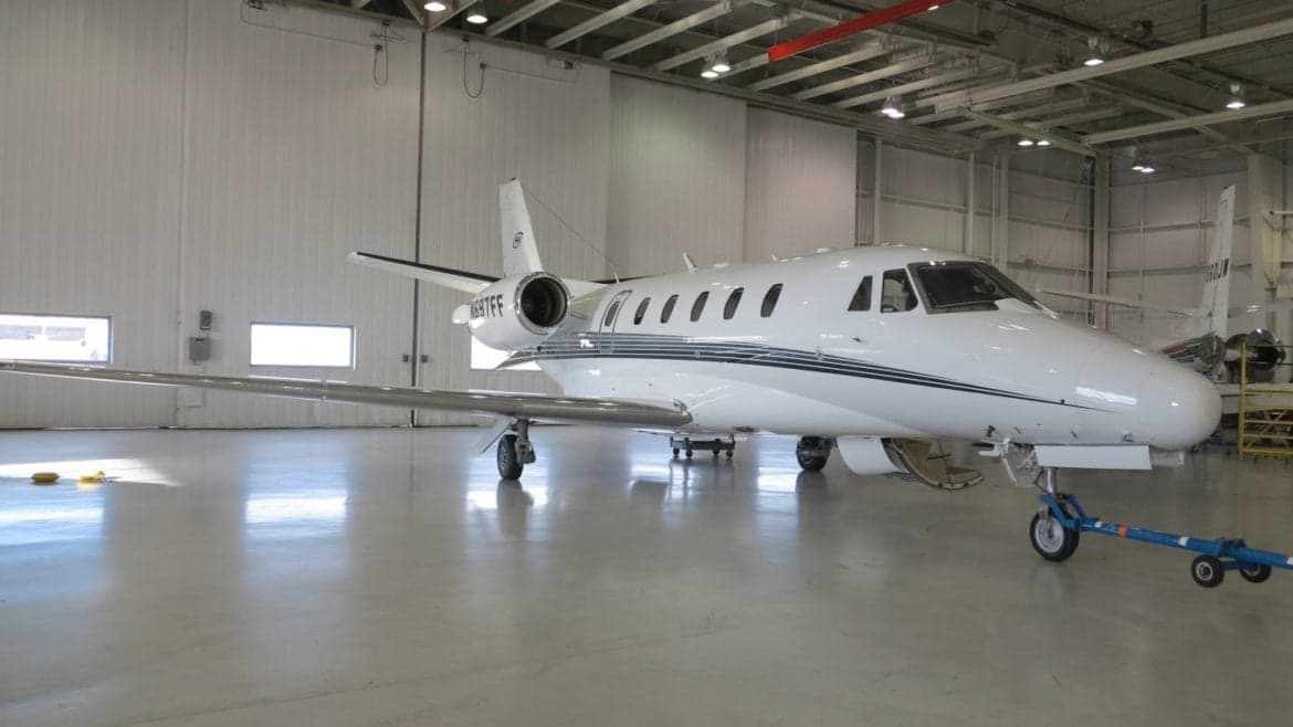 A Citation CJ3 aircraft with registration N697FF is parked inside a hangar.