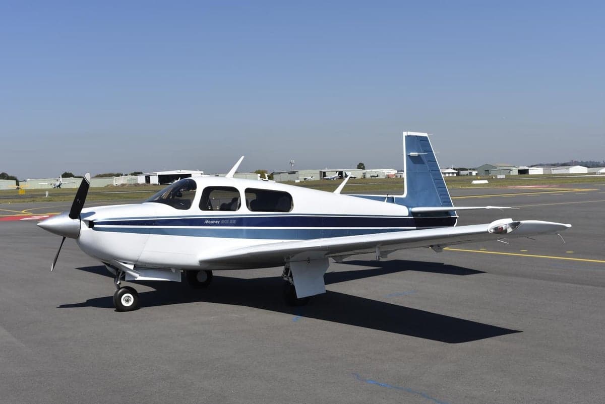 Mooney M20J 201 SE on the tarmac with a white and blue paint scheme.