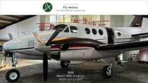 A Beech B90 King Air aircraft is parked inside a hangar.