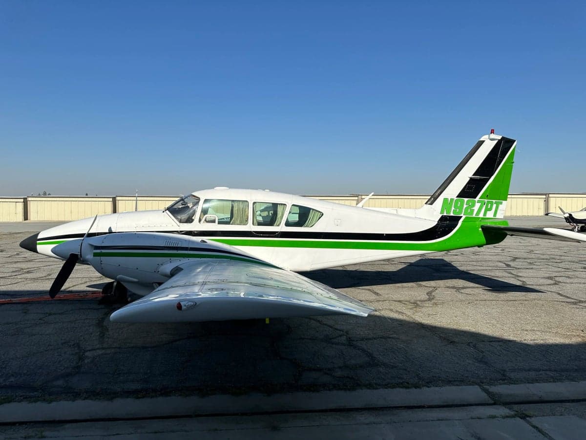 Side view of N927PT aircraft with green and black accents on the tail.