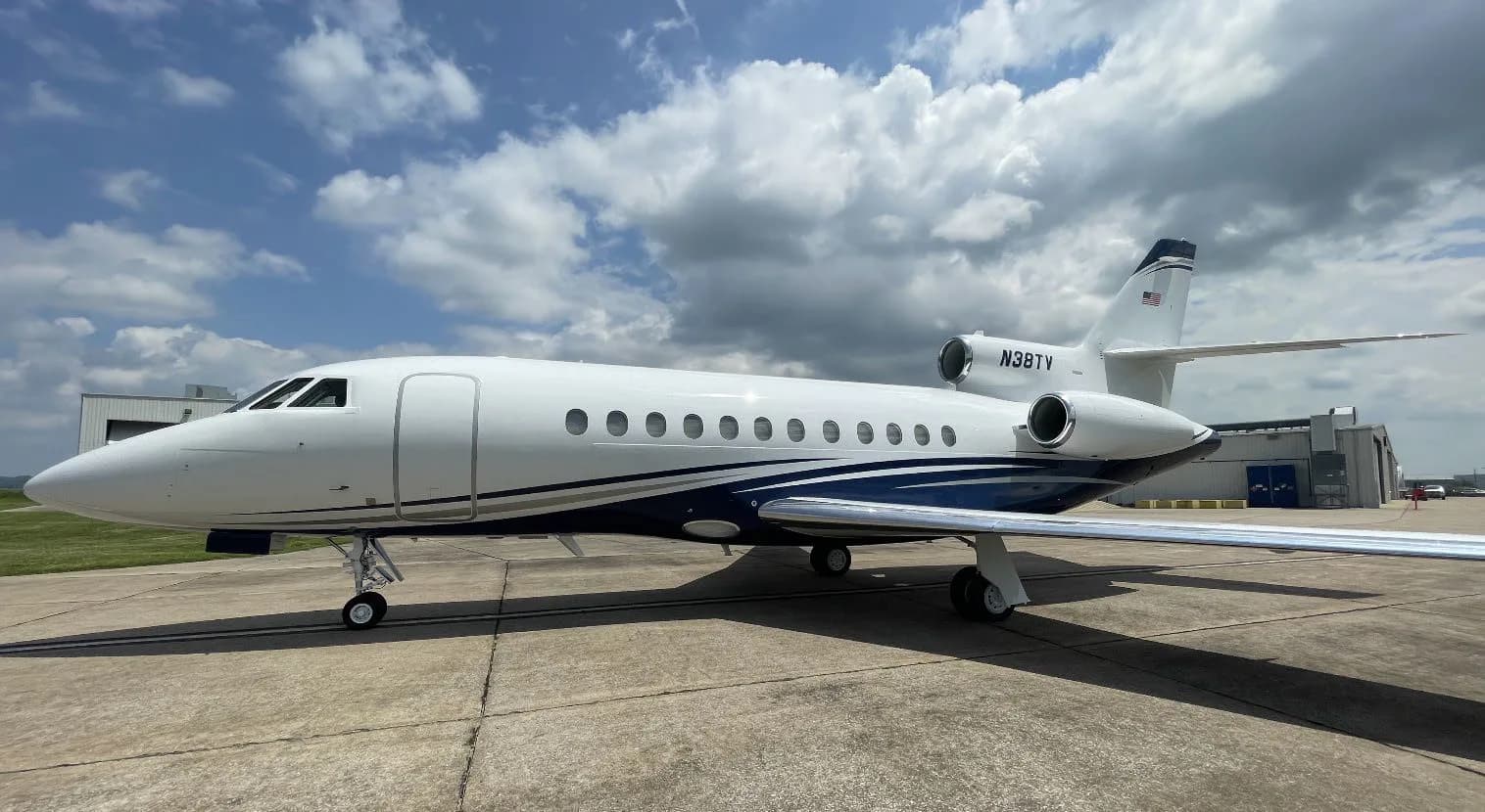 Side view of a white and blue aircraft with tail number N38TY on the tarmac.