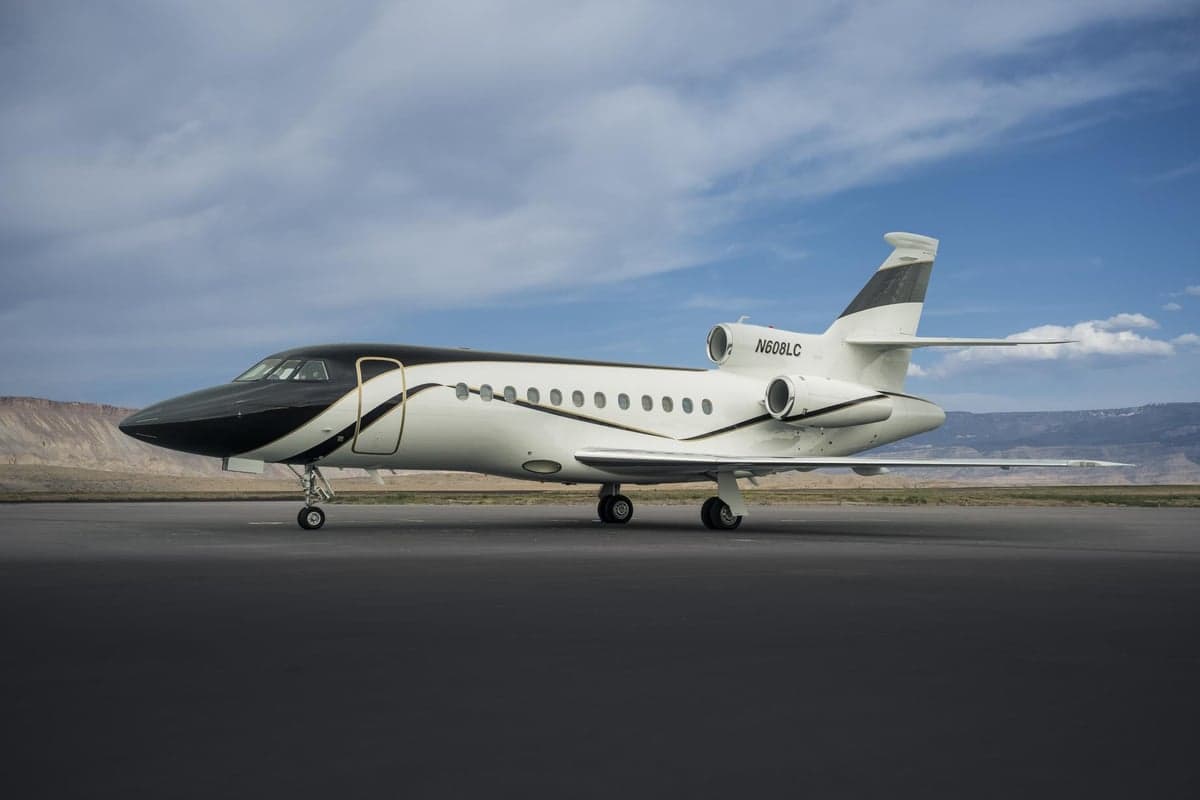 A Falcon aircraft with registration N608LC is parked on the tarmac.