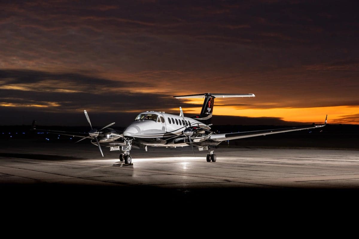 A King Air 350i aircraft is parked on the tarmac at dusk.