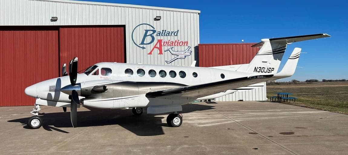 Beechcraft King Air 200 parked in front of a hangar.