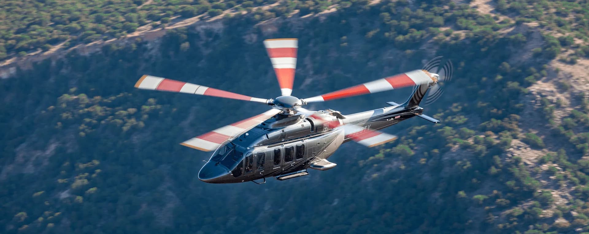 A helicopter flying over a mountainous landscape.