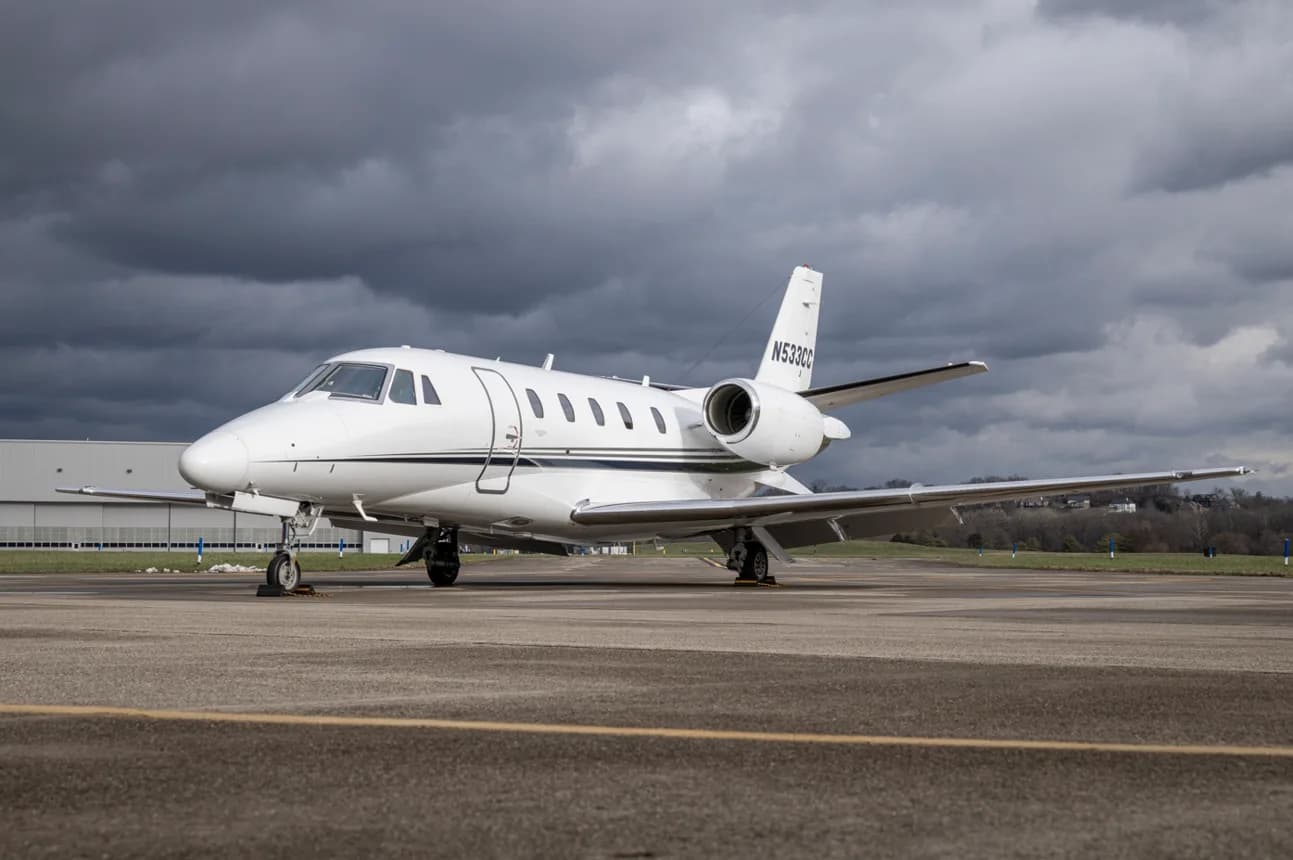 A white Cessna Citation business jet with tail number N533CC parked on an airport tarmac under a cloudy sky.