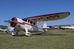 A Howard DGA-15P aircraft with a white and red paint scheme is parked on the grass.