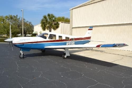A Piper PA-28-181 Archer II aircraft with registration N918L is parked on the tarmac in front of a hangar.