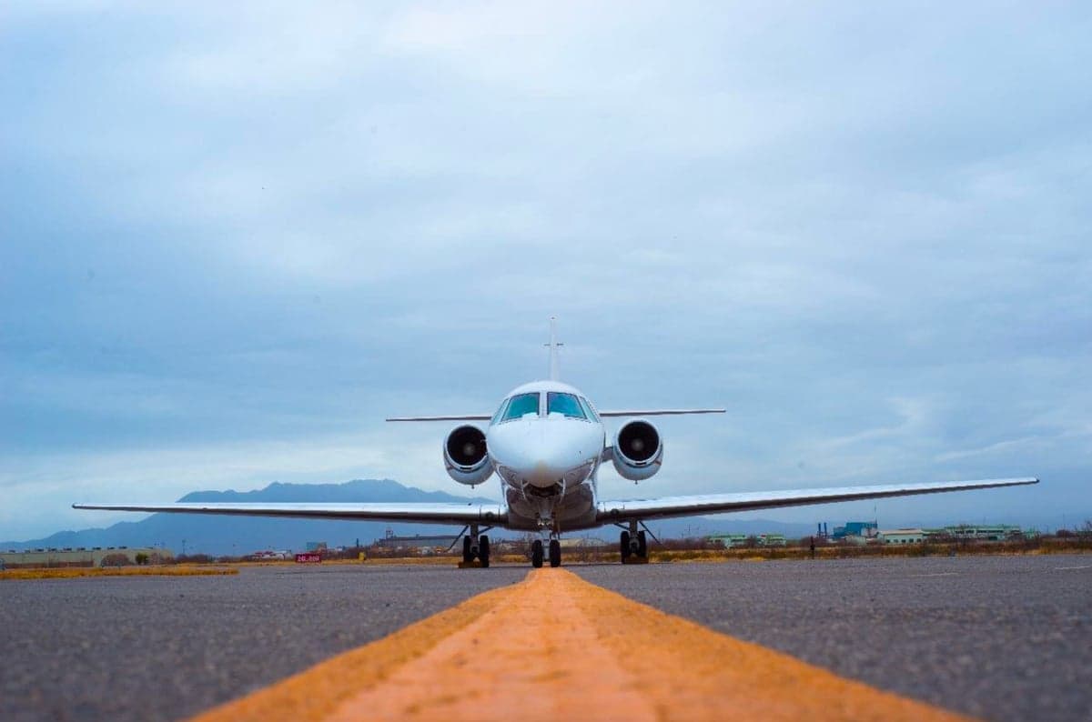 Front view of a white jet on the runway.