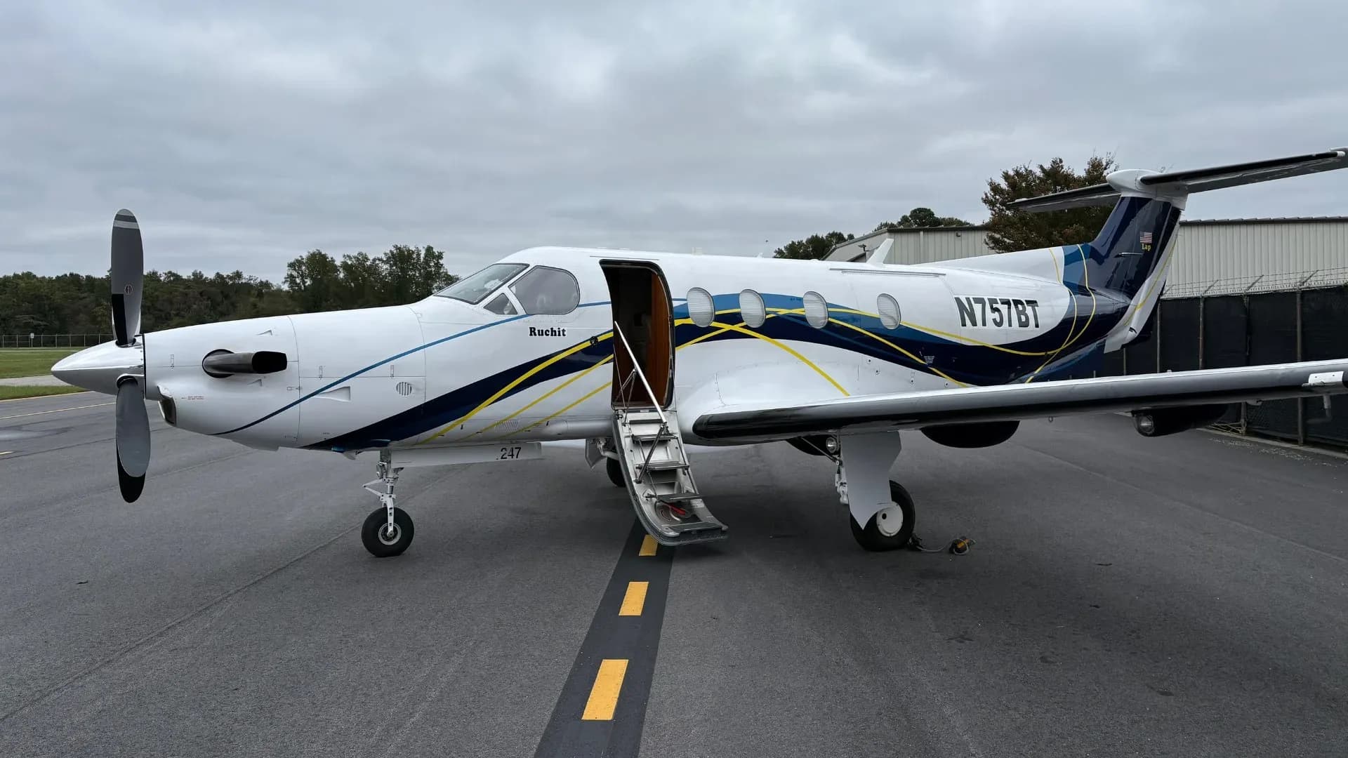 Pilatus PC-12 aircraft N757BT with door open on the tarmac.