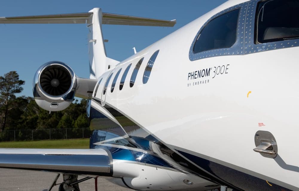 Close up of a Phenom 300E aircraft showing the engine and tail section.