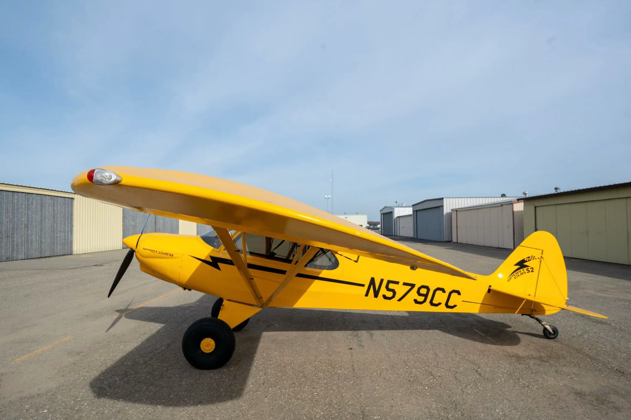 A yellow CubCrafters Sport Cub S2 aircraft with registration N579CC parked on an airfield.