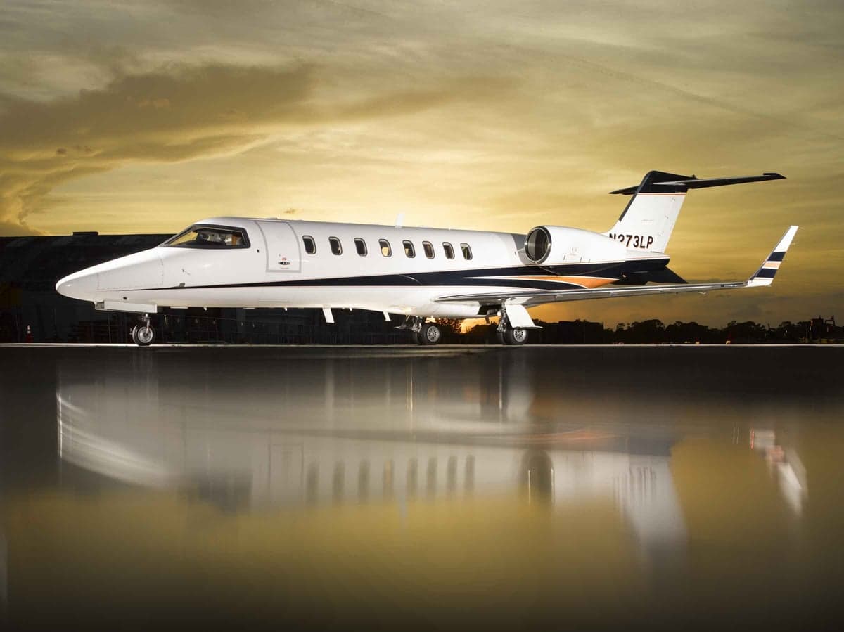 Side view of the N273LP aircraft on the ground with a reflective surface.