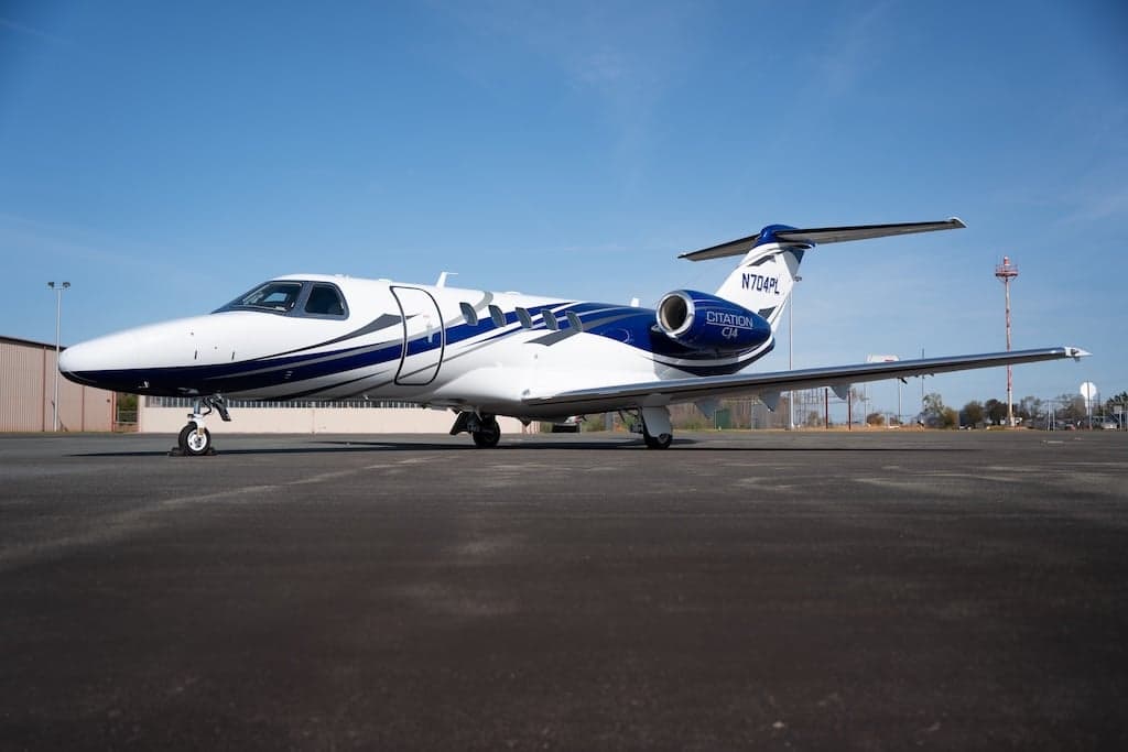 A Citation CJ4 aircraft with registration N704PL is parked on the tarmac.