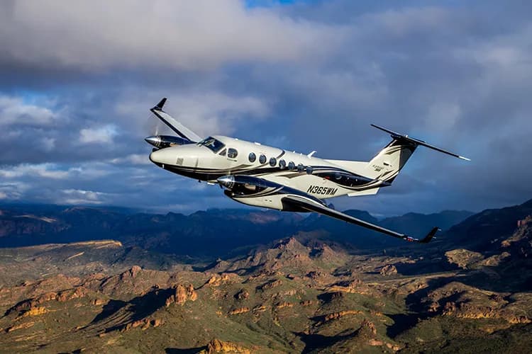 N365WM King Air flying over a mountainous landscape.