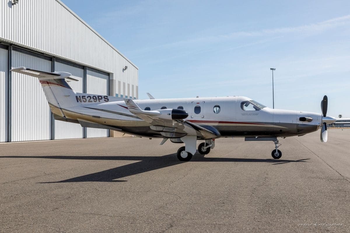 Pilatus PC-12 aircraft N529PS parked on the tarmac in front of a hangar.