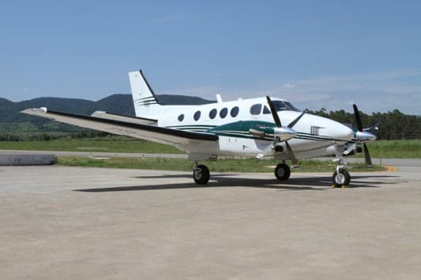 Beechcraft King Air 200 on the tarmac with green and white paint scheme.
