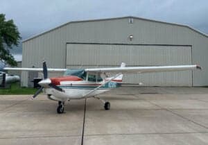 A Cessna 172 Skyhawk parked in front of a hangar.